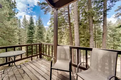 a deck with a table and chairs and trees at 1 Mi to Northstar Skiing Cozy Pet-Friendly Condo! in Truckee