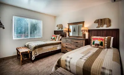 a bedroom with two beds and a dresser and a mirror at 12R Hilltop Haven in North Wawona
