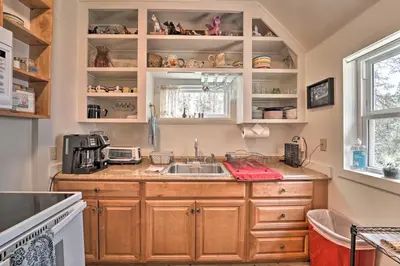 a kitchen with wooden cabinets and a sink at Half-Mi to Trails Rustic Soda Springs Cabin! in Soda Springs