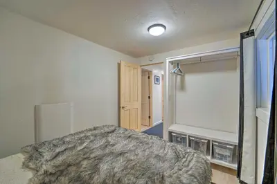 a bedroom with a bed and a mirror and a door at Half-Mi to Trails Rustic Soda Springs Cabin! in Soda Springs