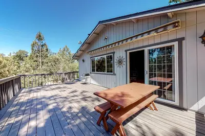 a wooden deck with a picnic table on a house at It's Cabin Time in Groveland