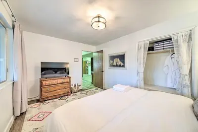 a bedroom with a white bed and a television at Pine Mountain Cabin with Hot Tub, 2 Mins to Marina! in Groveland