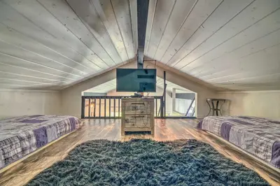 a large room with two beds and a flat screen tv at Cold Springs Escape AandC, Hot Tub, Generator, WiFi in Cold Springs