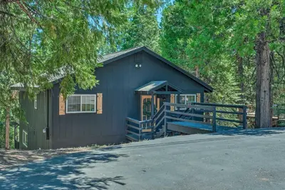 a black house with a porch and a fence at Cold Springs Escape AandC, Hot Tub, Generator, WiFi in Cold Springs