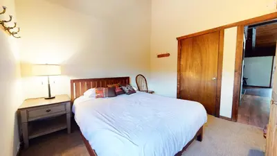 a bedroom with a bed and a table with a lamp at Mammoth Estates #113 condo in Mammoth Lakes