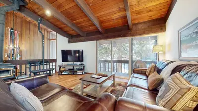 a living room with a leather couch and a television at Mammoth Estates #113 condo in Mammoth Lakes