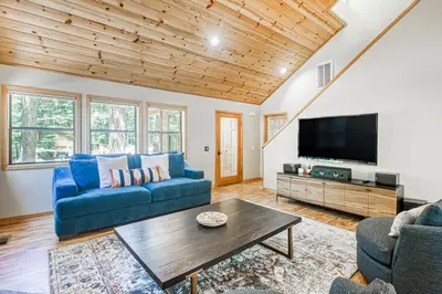 a living room with a blue couch and a tv at Blue Antler in Truckee