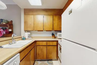 a kitchen with wooden cabinets and a white refrigerator at Tahome & Tahoe Place in Incline Village