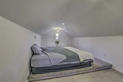 a bedroom with a large bed in a white room at Historic Reno Home on Riverwalk 1 Mi to Midtown in Reno