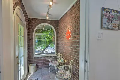 a brick hallway with two chairs and a window at Historic Reno Home on Riverwalk 1 Mi to Midtown in Reno