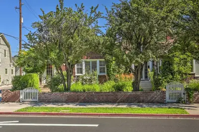 a brick house with two fences and trees at Historic Reno Home on Riverwalk 1 Mi to Midtown in Reno