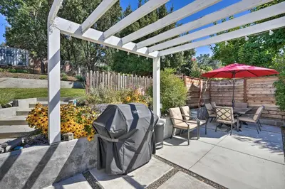 a white pergola with a table and chairs and an umbrella at Sierra Sunset Inn - 3 Miles to Placerville! in Placerville
