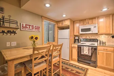 a kitchen with a wooden table and a white refrigerator at Cozy Family Condo in Mammoth Lakes with Balcony in Mammoth Lakes