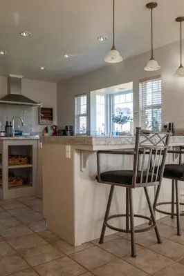 a kitchen with two chairs at a kitchen counter at Fraser Family Vineyard Estate Pet-Friendly Home in Plymouth