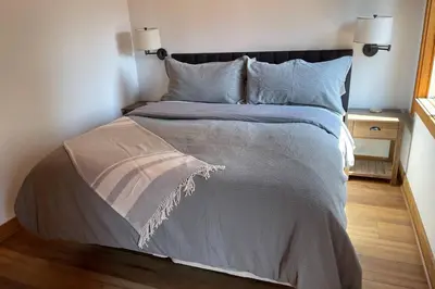 a bedroom with a bed with a gray comforter and pillows at DNA Chalet - Newly Renovated Townhome @ Northstar in Truckee