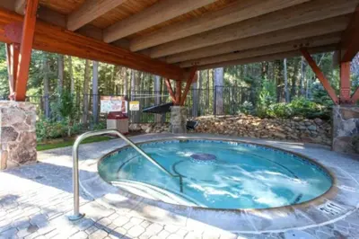 a hot tub in a patio with a wooden roof at DNA Chalet - Newly Renovated Townhome @ Northstar in Truckee
