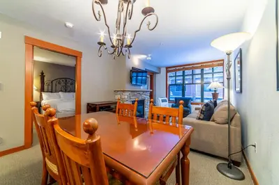 a dining room and living room with a table and chairs at Luxury Oasis Village Ski-in Ski-out in Mammoth Lakes