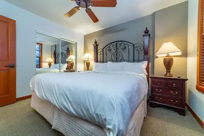 a bedroom with a large bed and a mirror at Luxury Oasis Village Ski-in Ski-out in Mammoth Lakes