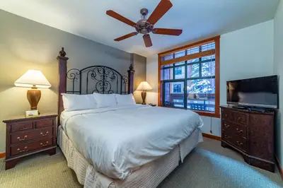 a bedroom with a large bed and a flat screen tv at Luxury Oasis Village Ski-in Ski-out in Mammoth Lakes