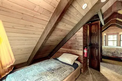 a bedroom with a bed in a room with wooden walls at Sierra Dream in South Lake Tahoe