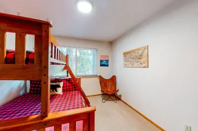 a bedroom with a bunk bed and a chair at Relax on Pretoria in Carnelian Bay