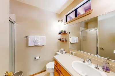 a bathroom with a sink and a toilet and a mirror at Relax on Pretoria in Carnelian Bay