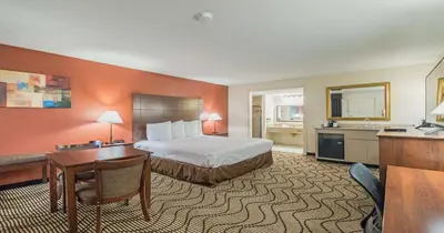 a hotel room with a bed and a desk at Best Western Roseville Inn in Roseville