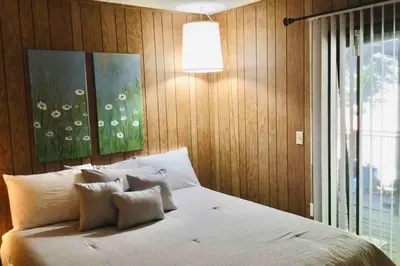 a bedroom with a white bed with two paintings on the wall at High Sierra Retreat with a view of Pinecrest lake in Pinecrest