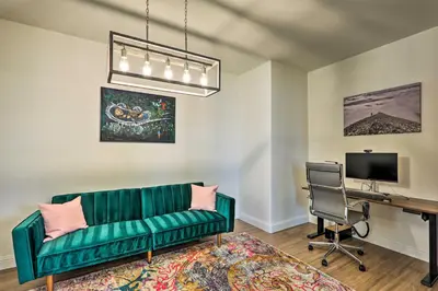 a living room with a green couch and a desk at 12 Mi to Riverwalk District Quiet Reno Retreat in Reno
