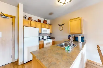 a kitchen with a sink and a white refrigerator at Juniper Springs 444 in Mammoth Lakes