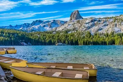 two boats on the shore of a lake with mountains at Westin 617 in Mammoth Lakes