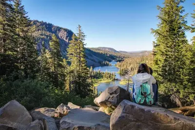 a woman sitting on a rock overlooking a lake at Forest Creek 12 in Mammoth Lakes