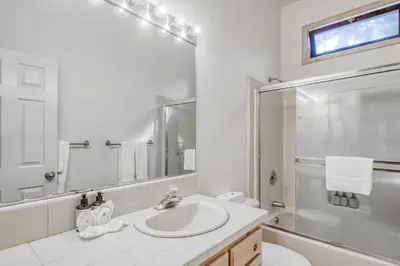 a white bathroom with a sink and a shower at Through the Trees in Truckee