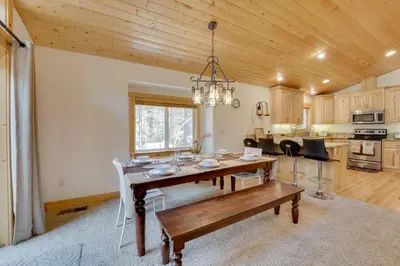 a dining room and kitchen with a table and a chandelier at Near Donner Lake and Skiing Soda Springs Cabin! in Soda Springs