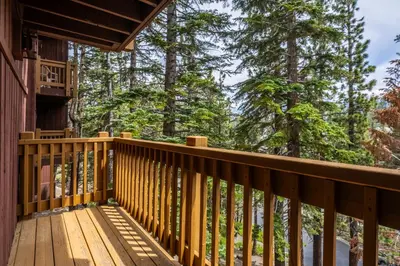 a deck of a cabin with trees in the background at Mammoth Ski Racquet Club 32 - Newly Remodeled Pet Friendly in Mammoth Lakes