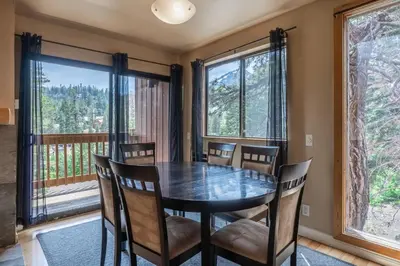 a dining room with a table and chairs and large windows at Mammoth Ski Racquet Club 32 - Newly Remodeled Pet Friendly in Mammoth Lakes