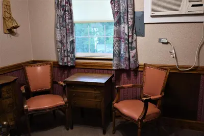 a room with two chairs and a desk and a window at Mariposa Hotel Inn in Mariposa