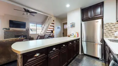 a kitchen with wooden cabinets and a stainless steel refrigerator at San Sierra #26 condo in Mammoth Lakes