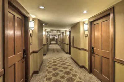 a hallway with wooden doors and a tile floor at 6 Mi to Lake Tahoe Everline Resort Retreat! in Olympic Valley