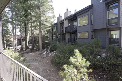 a house with a balcony and trees and bushes at St Anton Wooded View 1-Bedroom Condos with Complimentary Hot Drinks in Mammoth Lakes