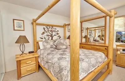 a bedroom with a four poster bed and a mirror at St Anton Wooded View 1-Bedroom Condos with Complimentary Hot Drinks in Mammoth Lakes