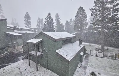 a house with snow on the roof of it at St Anton Courtyard View 2-Bedroom Condos with two oversized jacuzzi spas in Mammoth Lakes