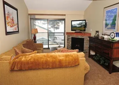a living room with a large couch and a fireplace at St Anton Street View 2-Bedroom Condo with full kitchen in Mammoth Lakes