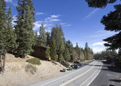 a street with cars parked on the side of a road with trees at St Anton Courtyard View 2-Bedroom Condo with full kitchen in Mammoth Lakes