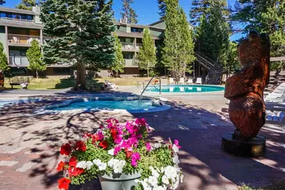 a statue of a bear and flowers in front of a pool at St Anton Courtyard View 1-Bedroom Condos with Dry Sauna in Mammoth Lakes
