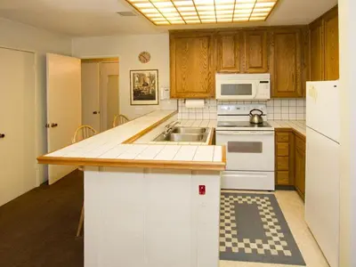 a kitchen with a sink and a white refrigerator at St Anton Courtyard View 1-Bedroom Condos with Dry Sauna in Mammoth Lakes