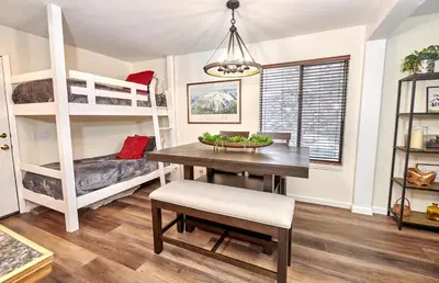 a dining room with a table and bunk beds at St Anton Courtyard View 1-Bedroom Condos with Dry Sauna in Mammoth Lakes