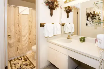 a white bathroom with a sink and a shower at St Anton Courtyard View 2-Bedroom Condos with Pool & Jacuzzi in Mammoth Lakes