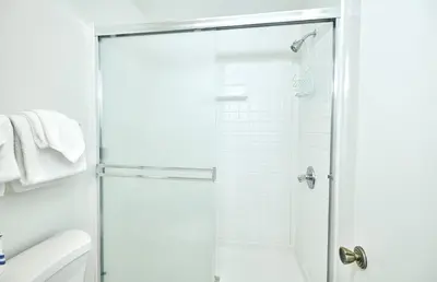 a white bathroom with a shower with a glass door at St Anton Wooded View 2-Bedroom Condos with Ski Lockers in Mammoth Lakes