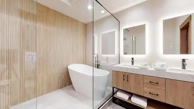 a bathroom with a tub and a sink and a mirror at Woodwinds #1265 townhouse in Mammoth Lakes